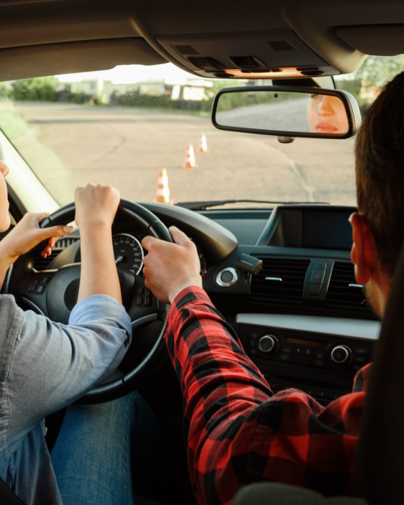 instructor-helps-woman-to-drive-the-car-1.jpg